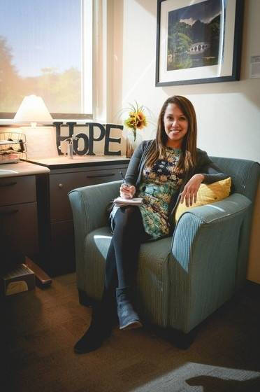 a picture of the employee ombuds sitting in a chair in an office setting